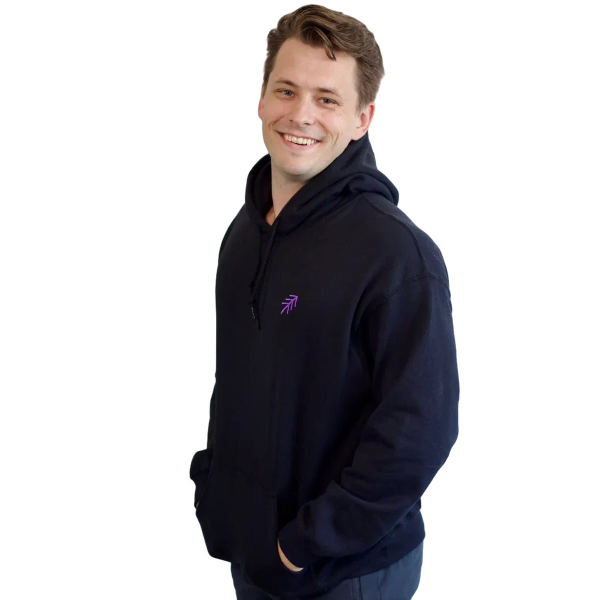 A smiling dancer wearing a black hoodie with a small purple embroidered pass logo on the left chest, posed against a solid white background.