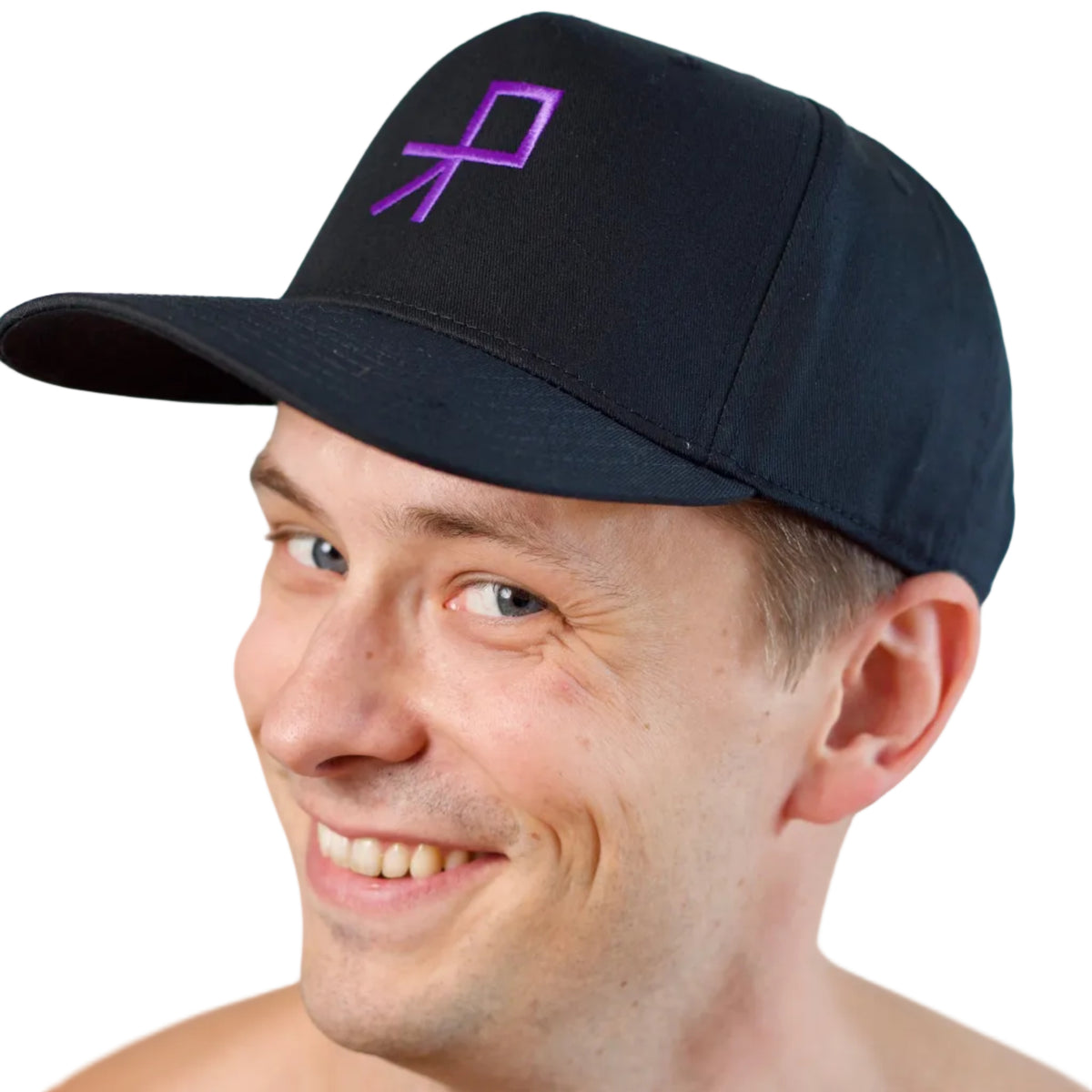 A smiling dancer wearing a black baseball cap with a purple push logo embroidered on the front, photographed against a plain white background. The left part of his head is turned slightly towards the camera.