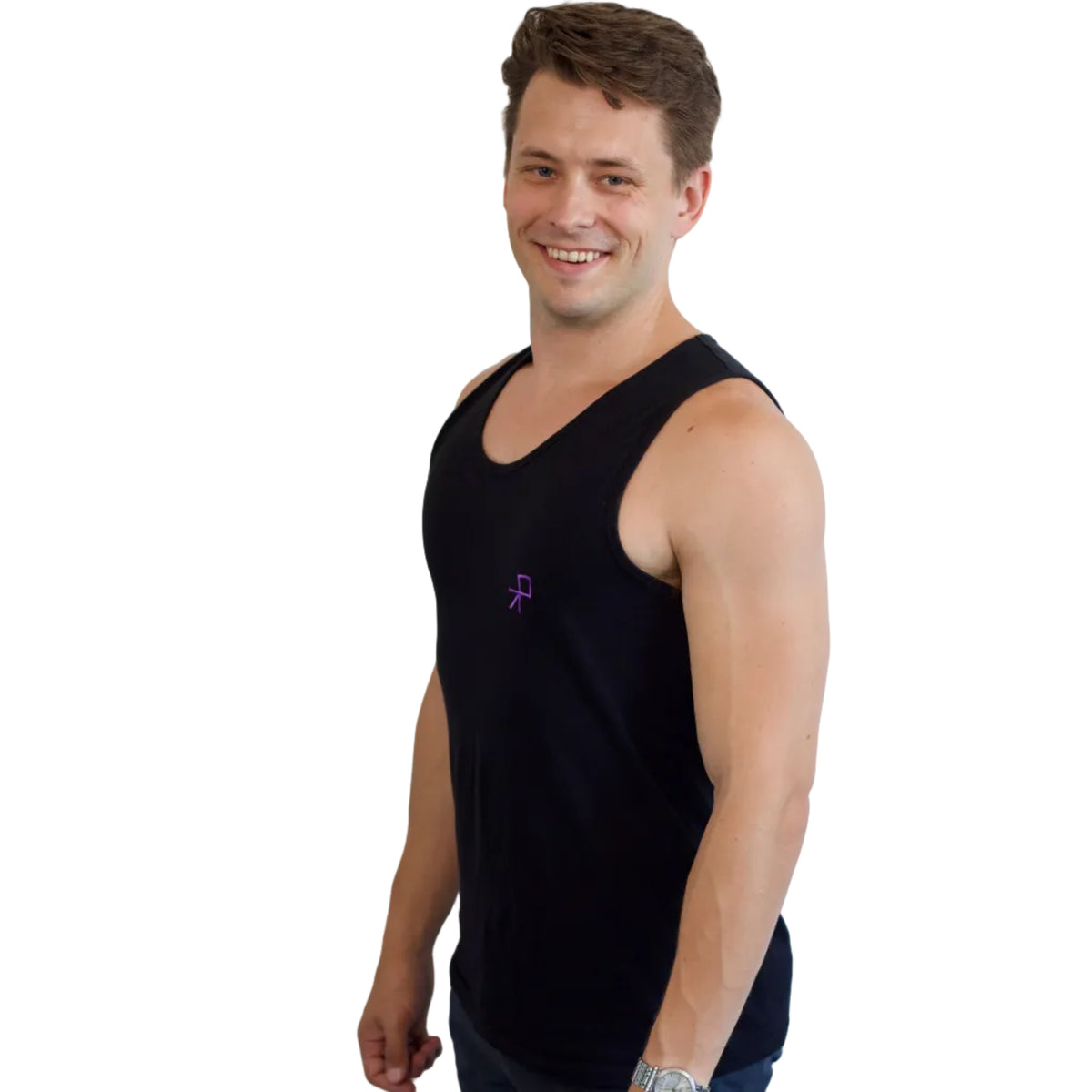 A smiling dancer wearing a black sleeveless tank top with a small purple embroidered push logo on the left chest, photographed against a plain white background.