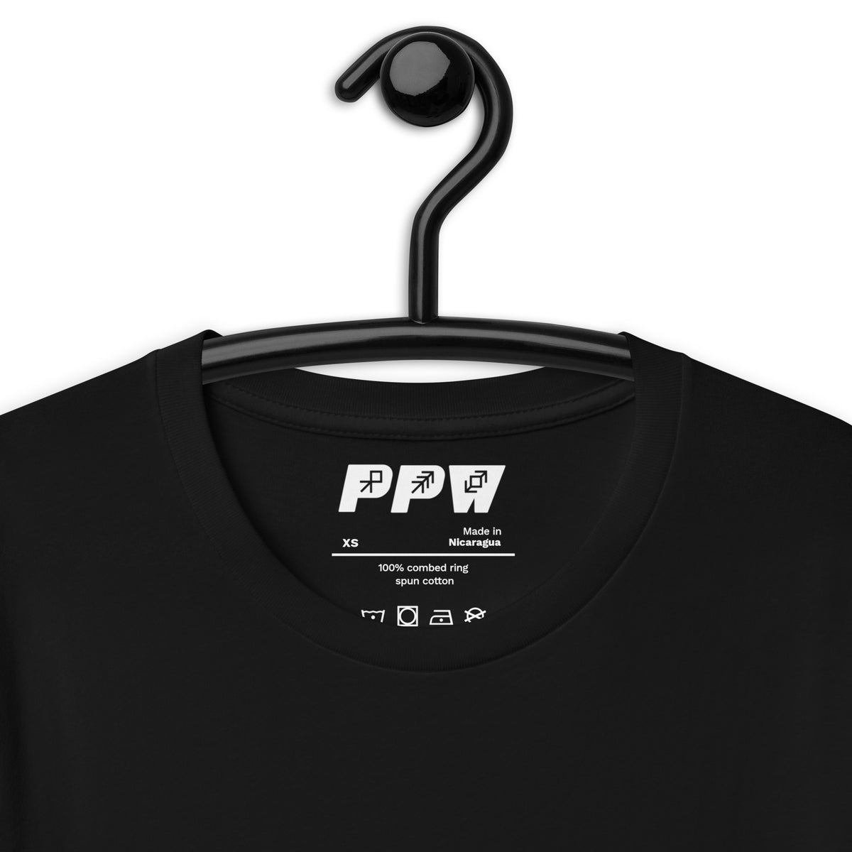 An example of a tshirt hanging on a plain black hanger, with the Push Pass Whip logo and the material information and care logo showing through the neck hole of the t-shirt. 