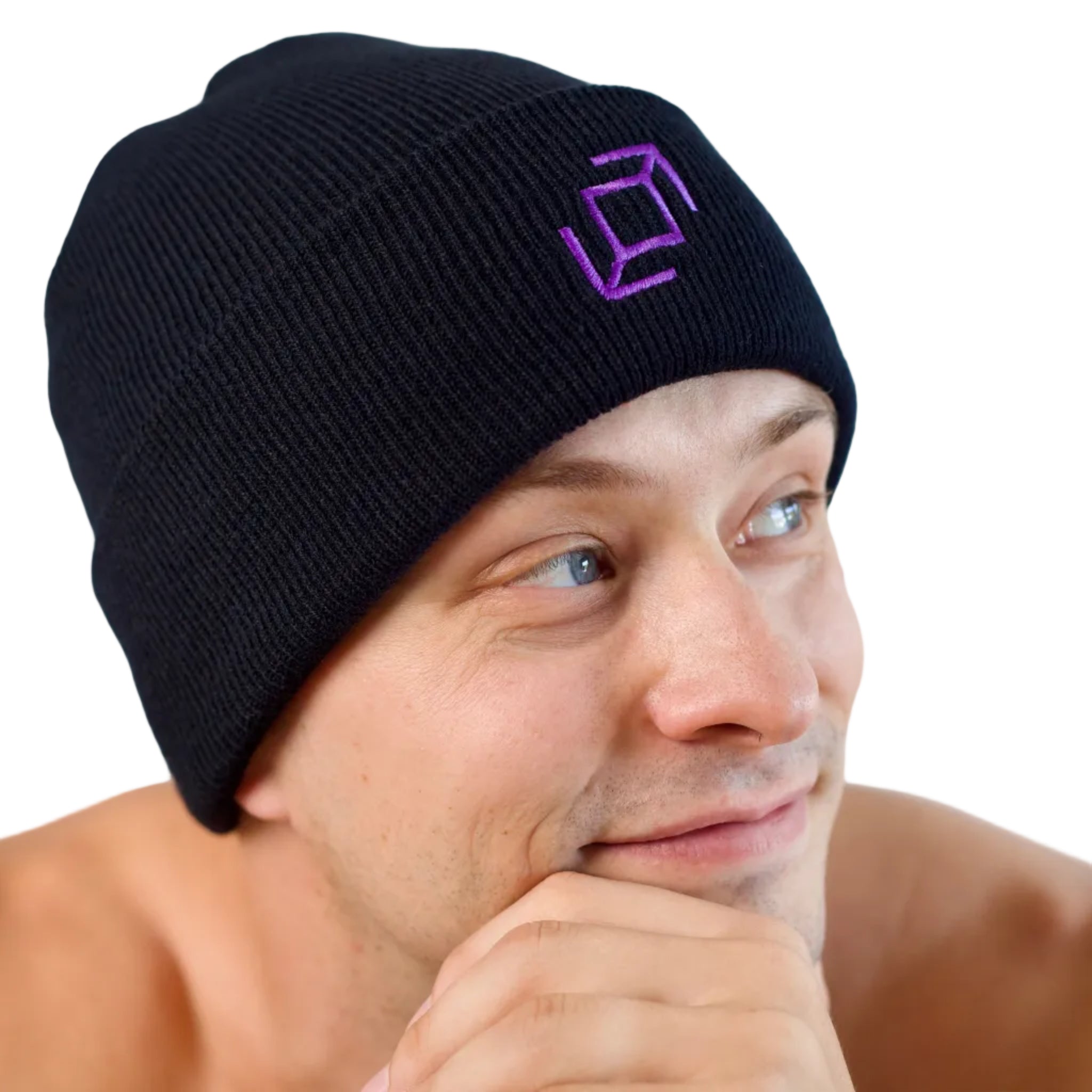 A close-up of a dancer wearing a black knit push pass whip beanie with a purple geometric whip logo embroidered on the front, set against a plain white background.