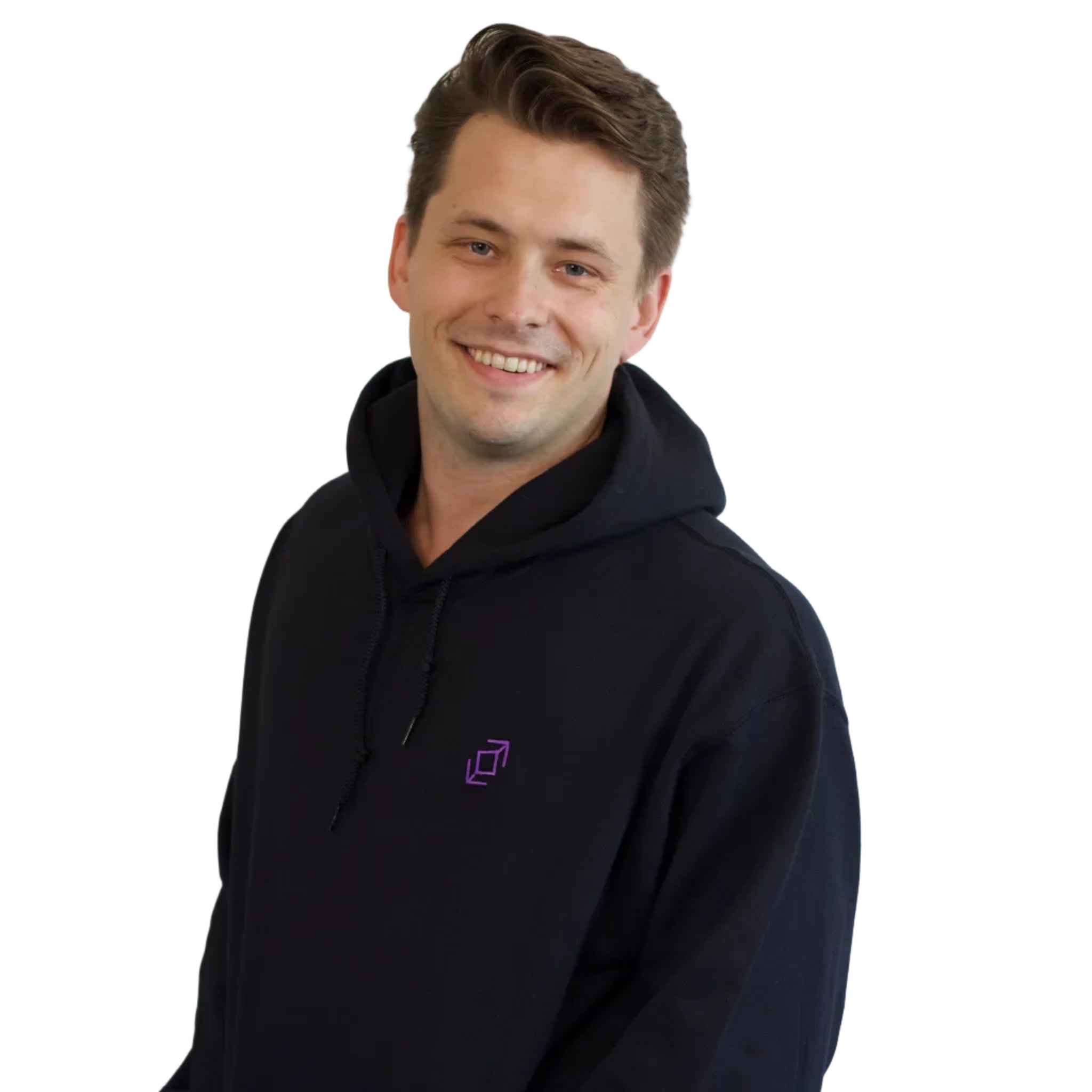 A smiling dancer with short brown hair wearing a black push pass whip pullover hoodie with a small purple geometric whip logo on the left chest, standing against a plain white background.