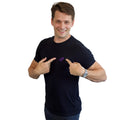 A standing dancer pointing to the logo on a black PPW Push tee showing the embroidered whip icon at chest height